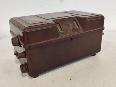 une vieille valise marron posée sur une table blanche