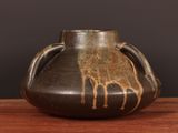 un vase marron orné d'une girafe, posé sur une table