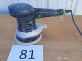 une photo d'une ponceuse posée sur une table sur laquelle figure un numéro