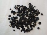 a pile of black buttons on a white surface