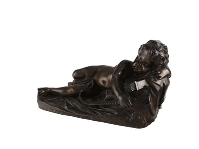 statue en bronze représentant un garçon allongé sur le ventre sur un oreiller
