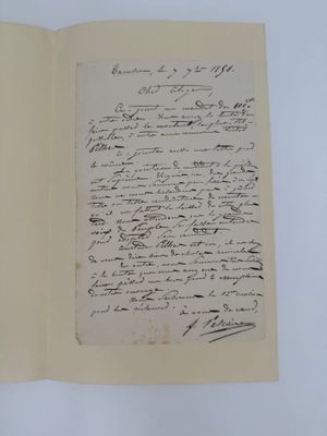 un livre ouvert avec une écriture dessus, posé sur une table