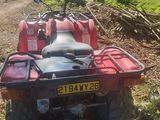 un quad rouge garé sur le bord d'un chemin de terre