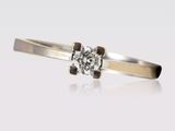 gros plan d'une bague en diamant sur une surface blanche