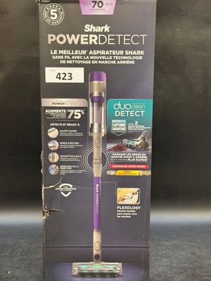 La boîte de l'aspirateur Shark PowerDetect est ouverte sur la table.