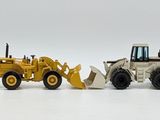five toy construction vehicles lined up in a row