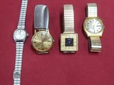 trois montres et un bracelet de montre posés sur un tissu rouge