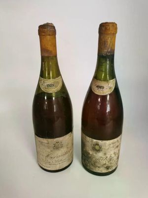 two bottles of wine sitting next to each other on a white surface