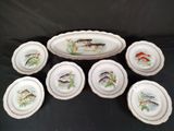 six assiettes sur lesquelles sont peints des poissons sur fond noir