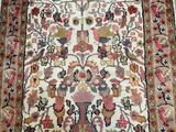 an antique persian rug with a floral design on a white ground