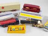beaucoup de camions miniatures et un bus posés sur une surface blanche
