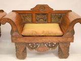 pair of antique carved wood chairs with yellow cushions on a white background