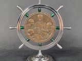 une image représentant une horloge argentée et verte sur laquelle repose une pièce de monnaie