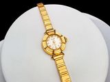 an image of a close up of a gold watch on a white plate