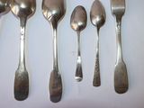 five spoons and two spoons sitting on a table