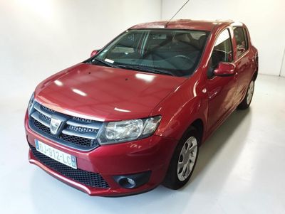 La voiture rouge est garée dans une pièce blanche au sol blanc.