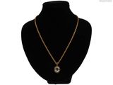 un collier composé d'une chaîne en or et d'un pendentif en pierre bleue