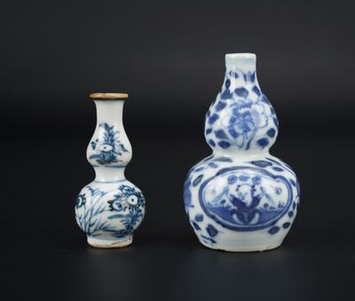 two blue and white vases sitting next to each other on a black surface