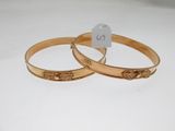 pair of gold tone bangles with engraved design on each side