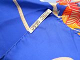 a close up of a blue shirt with a red and yellow flower on it