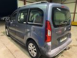 the back of a small grey van parked in a garage