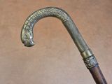 a close up of a metal and wood stick with a snake head on it