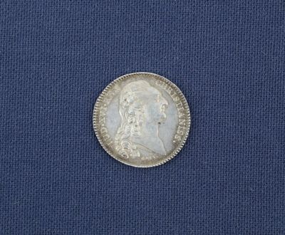 un gros plan d'une pièce de monnaie posée sur un tissu bleu