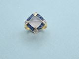 une bague sertie d'un diamant et d'un saphir sur un fond bleu
