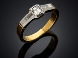 an engagement ring with a baguet cut diamond set in 18k yellow gold
