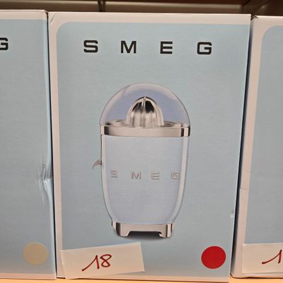 trois boîtes contenant chacune un presse-agrumes, posées sur une étagère