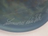 a blue vase with writing on it sitting on a table