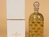 l'image d'un flacon de parfum posé à côté d'une boîte