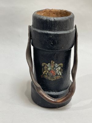a black vase with a handle on a white table