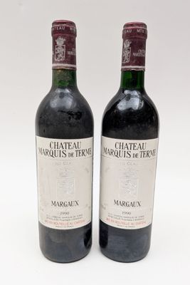 deux bouteilles de vin rouge posées l'une à côté de l'autre sur une surface blanche