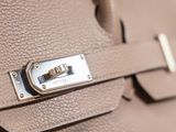 the handle of a handbag with a metal lock on it