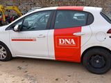 a small white and red car parked in a parking lot