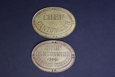 two old brass coins with the names of different companies