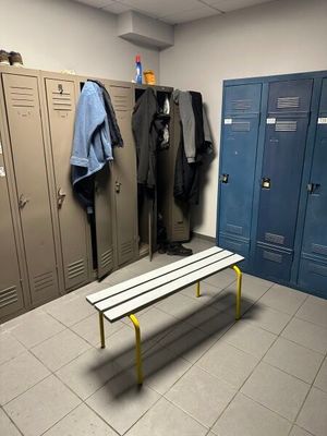 un banc au milieu d'une pièce, avec des casiers en arrière-plan
