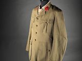 an old military uniform on a mannequin stand against a gray background