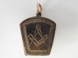 un pendentif plaqué or représentant un paysage de montagne