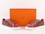 a pair of pink sneakers with gold detailing and a box