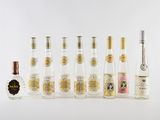 plusieurs bouteilles d'alcool sont alignées sur une surface blanche