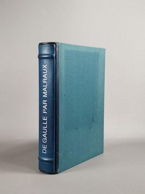 Le livre bleu est posé sur la table, à côté du livre bleu clair.