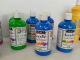 many bottles of different colors of paint on a table