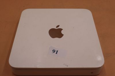 un ordinateur Apple posé sur une table, sur lequel est collé un autocollant