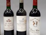 four bottles of wine are lined up on a white surface