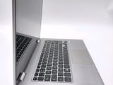 a silver laptop with a black keyboard on a white surface