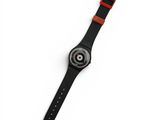 a close up of a watch on a white surface with a red band