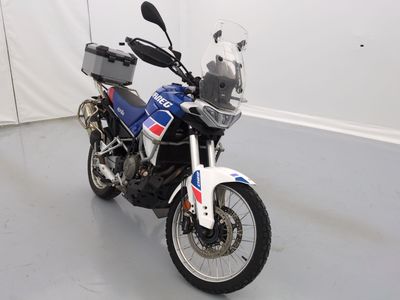 une moto bleue et blanche garée dans une pièce blanche