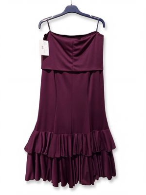a purple dress hanging on a hanger on a white wall